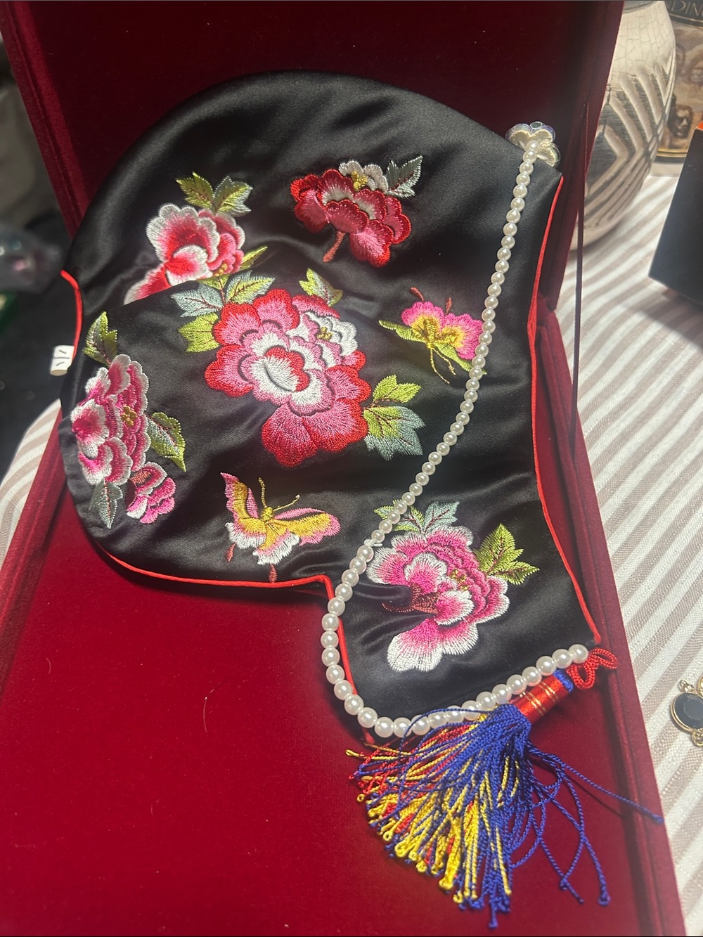 traditional Korean jobawi cap made of black fabric adorned with vibrant pink